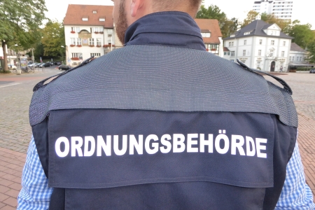 ein Beamter trägt eine Jacke mit der Aufschrift Ordnungsbehörde